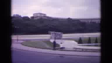 Paris France (1962): A Car Drives Past Two People On Turn Road In The City