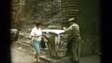 Rome Italy (1962): Woman Wearing Green Skirt Gives Small Object To Man Wearing