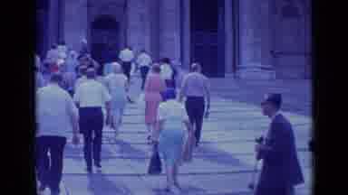 Rome Italy (1962): Woman Wearing Blue Skirt Walks Up To Tan Building On A Sunny
