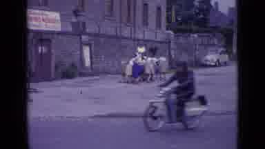 Switzerland (1962): Group Of People Huddled Up Closely Carry Something Past The