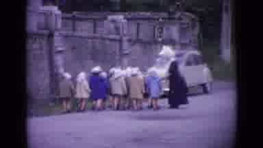 Switzerland (1962): Children Walking With Nun On Road Near Stone Wall