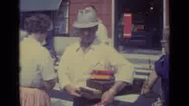 Vatican City (1962): Man Wearing Grey Hat Carries Brown Boxes On A Bright Sunny