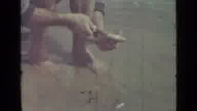 Saint Petersburg Russia (1967): A Man Squatting In A River Or Lake Gutting A Fish