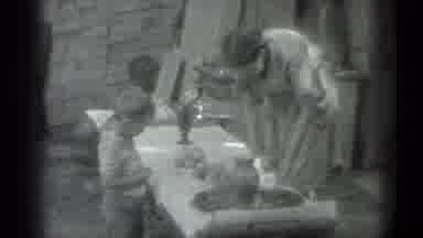 Moscow Russia (1983): Woman Prepares Food For Young Child
