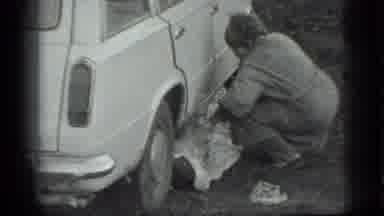 Moscow Russia (1983): Woman Is Covering Up A Person Underneath The Car