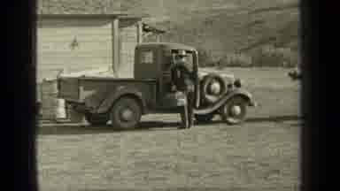 Bend Oregon (1937): Man Unpacks His Car As Woman Walks Towards The Camera