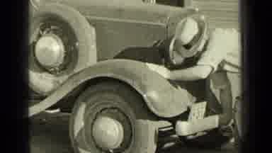 Bend Oregon (1937): Guy Cranking Up The Car While Two Women Are Hopping The Fence