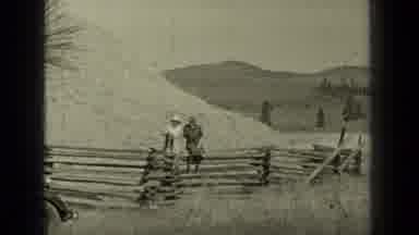 Bend Oregon (1937): Dog Hops The Fence And Runs Across The Grassy Field As The Two