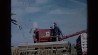 Minnesota USA (1958): Army Man Looking Over Machine In A Country Field Next To A