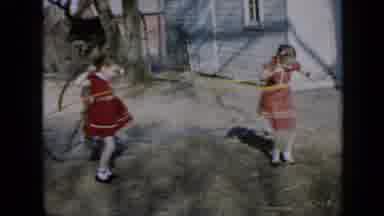 Minnesota USA (1958): Two Girls Playing On The Sidewalk With Bamboos
