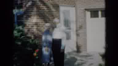 Minnesota USA (1958): Couple In Front Of Their Residence In The Shade Of Trees On