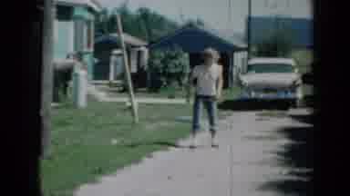 Minnesota USA (1958): Girl Stands In Front Of Her Home And Shakes Her Hula Hoop