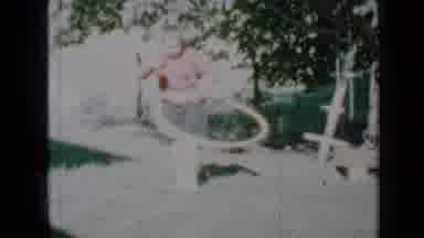 Minnesota USA (1958): A Young Girl In A Pick Sweater Hula Hoops Outside