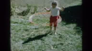 Minnesota USA (1958): A Young Blonde Girl With A Ponytail Plays With A Hula Hoop