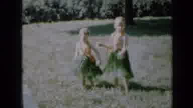 Minnesota USA (1958): Two Girls In Hawaiian Attire Dancing On The Yard