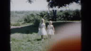 Minnesota USA (1958): Children Walking Across The Grass Outside Their Home On A