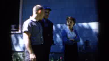 Minnesota USA (1958): Three Young White People Stare At The Camera And Wave A Tit