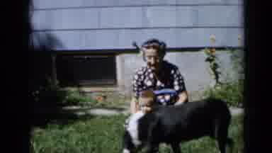Minnesota USA (1958): An Older Women Sits In A Grassy Yard With A Baby In Her Lap