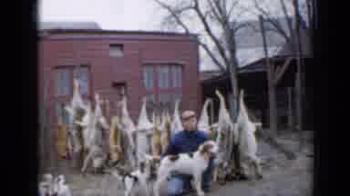 Minnesota USA (1958): Man Smiles As He Plays With Mother Dog And Three Puppies On