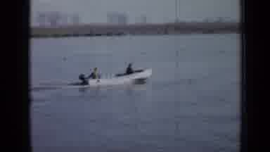 Minnesota USA (1958): A Boat Speeds By With Two Men As Two Other Men Talk On