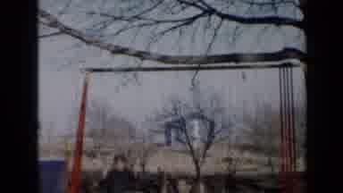Minnesota USA (1958): Girl Wearing Blue Dress Swings And Slides Down Slide Of