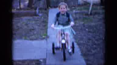 Minnesota USA (1958): Two Kids Are Bicycling Down A Sidewalk On A Slightly Cloudy