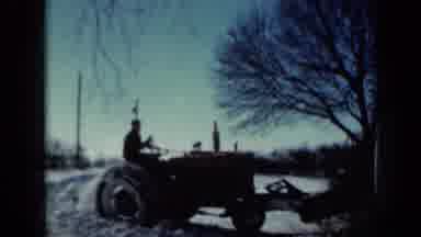 Minnesota USA (1958): Man Without Hat Drives Tractor Equipped With Plow To Clear