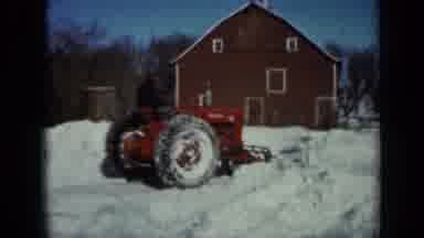 Minnesota USA (1958): Red Tractor Plowing Freshly Fallen Snow Next To A Red Barn