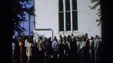 Aledo Texas (1959): Large Crowd Standing Next To White Building On A Bright Sunny