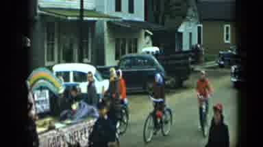 Aledo Texas (1959): Girls Follow Parade Float On Bicycles On A Clear Day