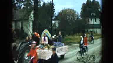 Aledo Texas (1959): Two Girls Following Parade Float On Bicycles On A Sunny Day