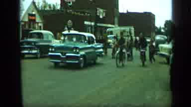Aledo Texas (1959): Tons Of Kids In Bikes Following A Car Going Down A Road