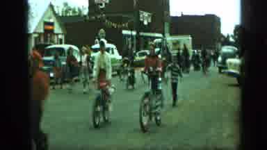 Aledo Texas (1959): People In Groups With Bikes Riding Down A Street