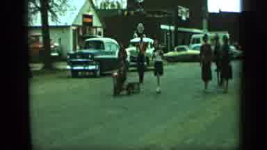 Aledo Texas (1959): Boy Wearing Tan Hat Rides Burro Down Street On A Cloudy Day
