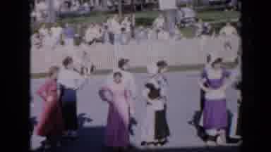 Iowa USA (1959): Several Women In Traditional Dress Dance In A Line Together