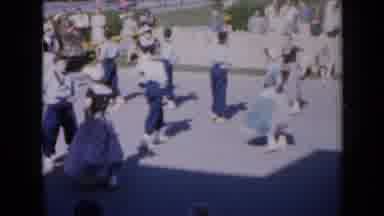 Iowa USA (1959): Group Of Dancers Wearing Blue Performing On A Sunny Day