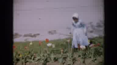 Iowa USA (1959): Girl Wearing A Blue Dress And Bluebonnet Walking In A Field