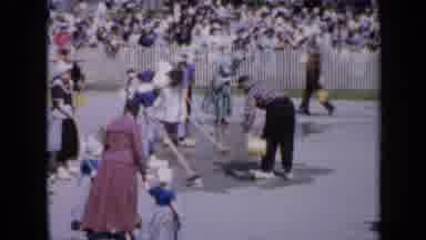 Iowa USA (1959): People Wearing White Hats Clean Courtyard On A Bright Sunny Day