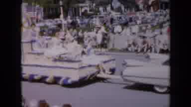 Iowa USA (1959): A Float With Four Beauties Is Passed By Two Girls On A Bike