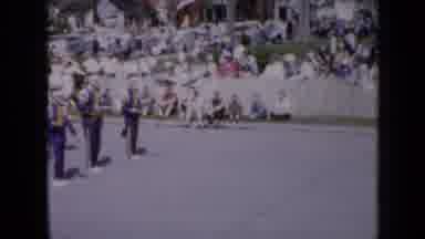 Iowa USA (1959): Band Wearing Blue And Yellow Uniforms March In Place On A Bright