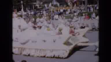 Iowa USA (1959): Parade Float With Festival Queen Waving To Crowds Of Onlookers