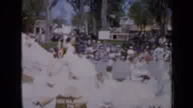 Iowa USA (1959): People Sitting On A Float Waving Towards People As The Slowly Go