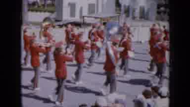 Iowa USA (1959): Marching Musical Group Entertains Crowd In Parade Through Small