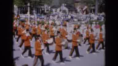Iowa USA (1959): Orange And Black Clad Marching Band In A Parade