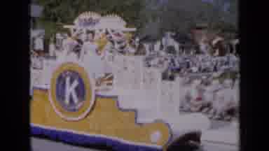 Iowa USA (1959): Lawn Tractor Pulls Two Carts And A Float In The Annual Parade