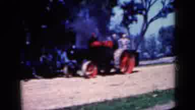 Iowa USA (1959): Farm Vehicle Makes Slow Approach With Wheels Turning And Smoke
