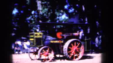 Iowa USA (1959): Large Red Truck Driving Through Field Behind A Large Steam Engine