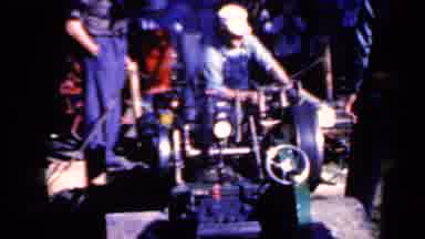 Iowa USA (1959): Old Man Operates Power Driven Log Trimmer With An Assistant
