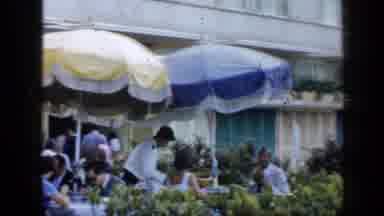 VENEZUELA-1959: Customers Sit At Outdoor Tables Under Umbrellas At A Restaurant
