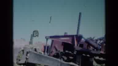 Missouri USA (1961): Man Wearing A Fedora Rides On Tractor Over A Field Of Crops